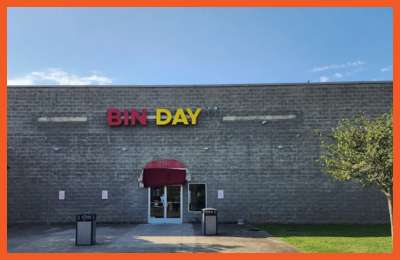 Exterior view of Bin Day – Antioch/Cane Ridge with a gray brick facade and bold red and yellow store sign above the entrance.